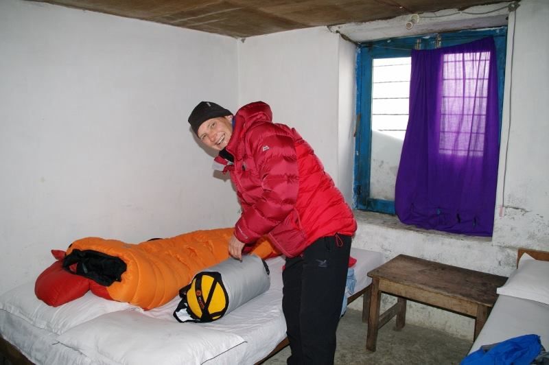 man smiling while packing to trek